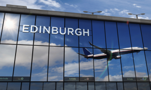 Edinburgh airport exterior with image of place taking off in blue skies